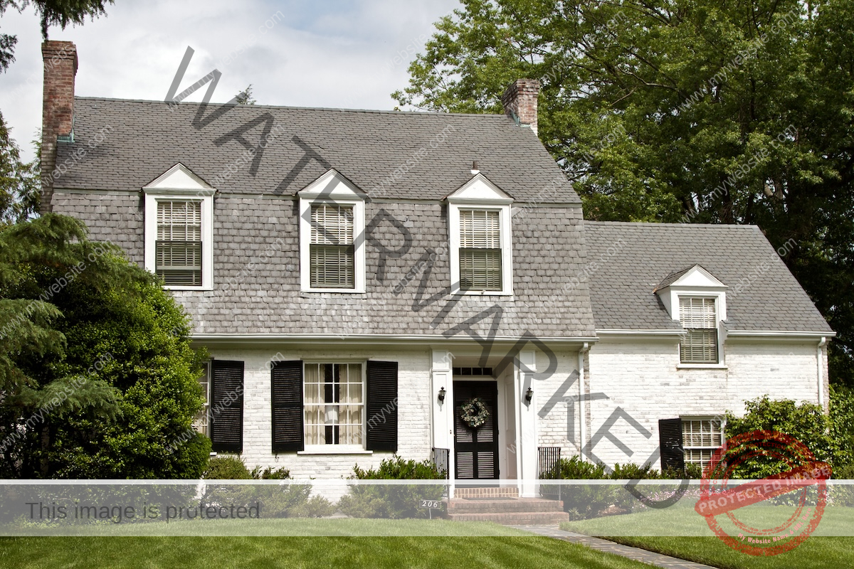 A farmhouse style home that is painted white with black trim and window treatments.