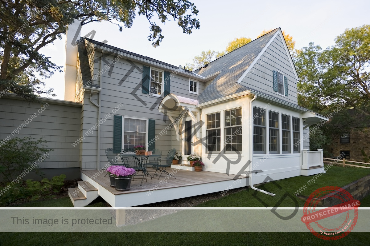 A gray house with a screen porch and teal-colored window shutters. 