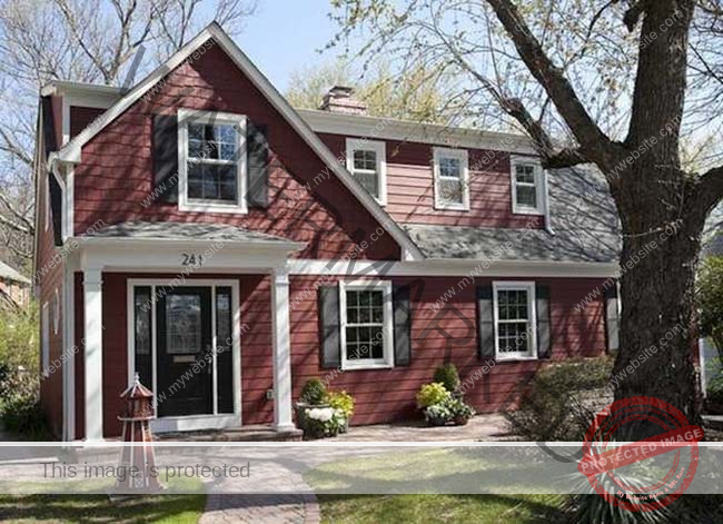 A red house with black decorations on the windows. 