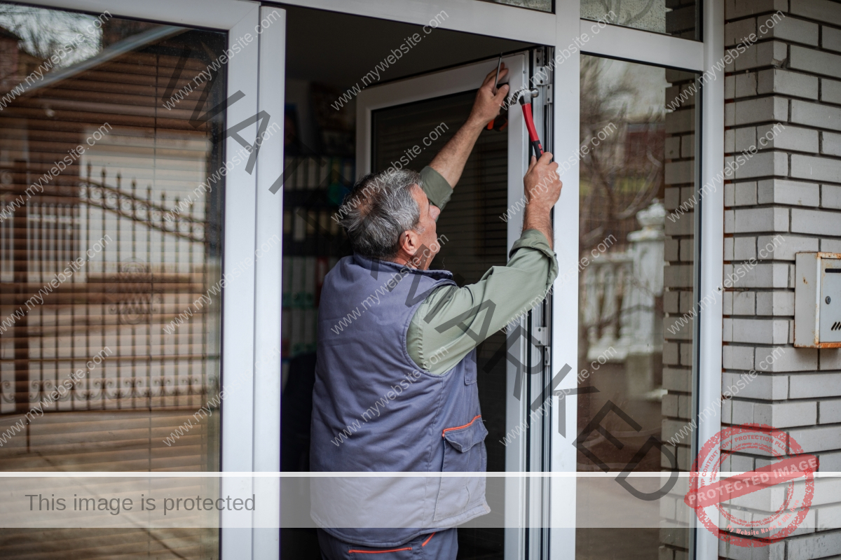 An older man is installing a storm door.