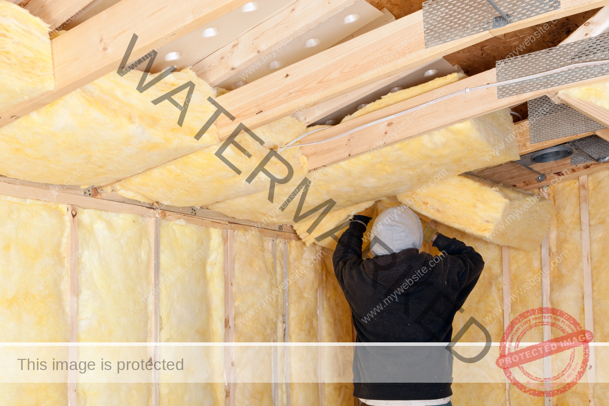 Man installing batt insulation in attic.