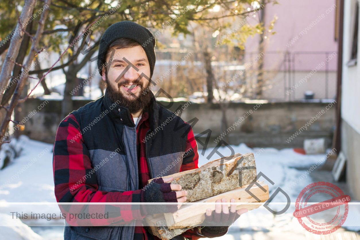 Man wearing vest and buffalo check wool carrying firewood.