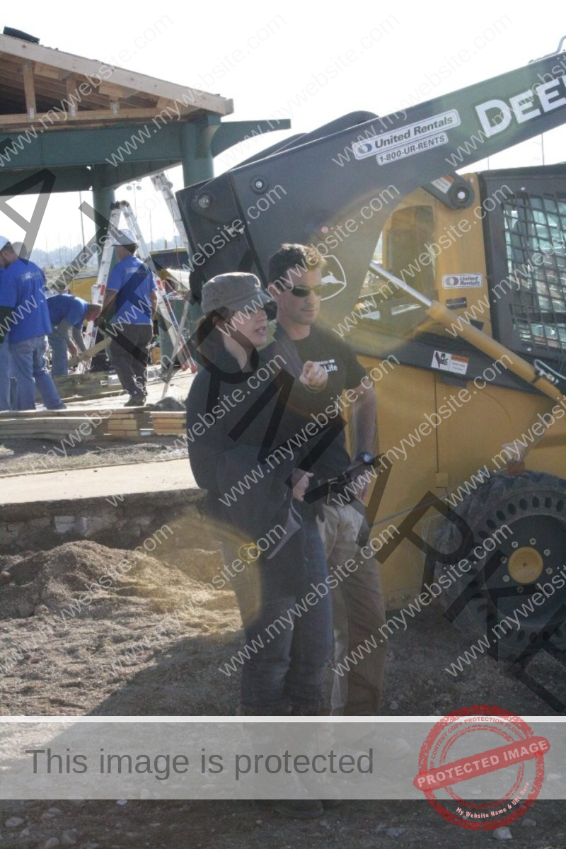 Two men are supervising a project near large construction equipment.