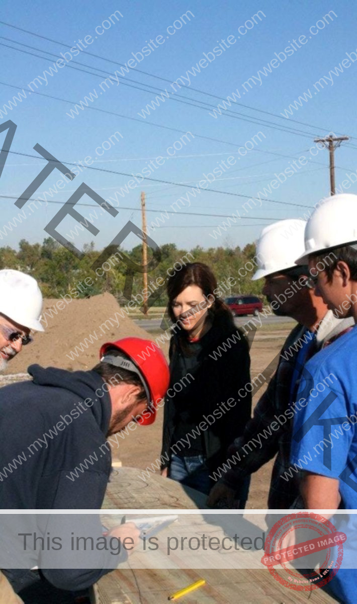 A group of people are looking at design plans.