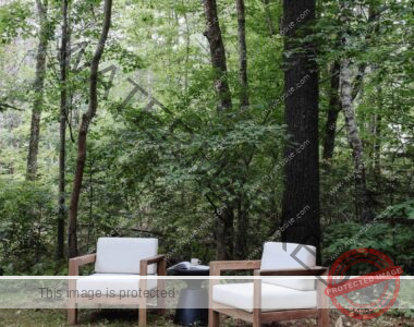 Outdoor seating in our wooded backyard. Wood and white cushioned outdoor chairs. , Nadine Stay