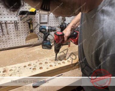 Man using a Milwaukee M18 hammer drill to drill holes in wood