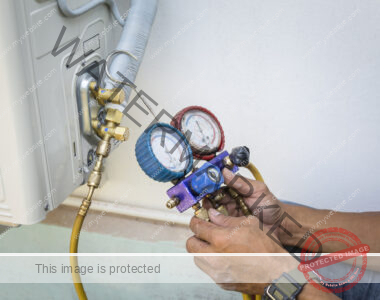 An HVAC technician uses a manometer to check the air pressure of a heat pump system.